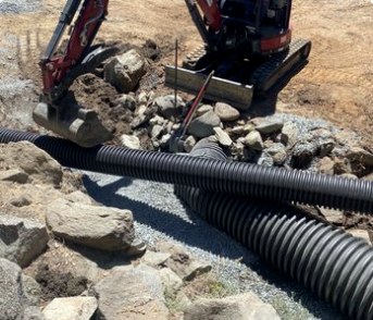 Excavation drainage work with pipe and rock